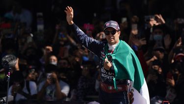 El piloto mexicano Sergio Checo Pérez saluda al público durante una exhibición con su monoplaza Red Bull en el Paseo de la Reforma, previo al Gran Premio de México