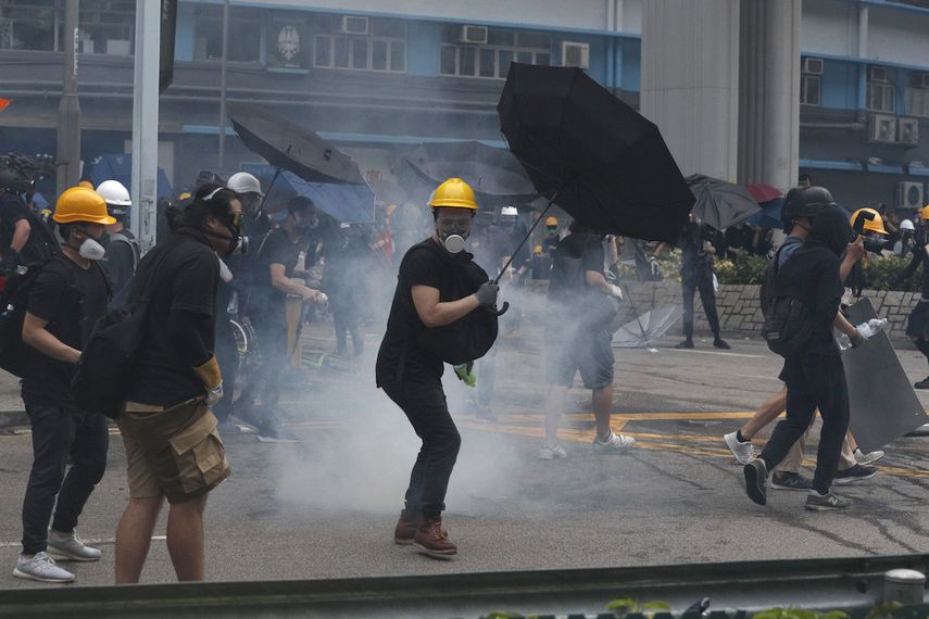 Manifestantes devuelven granadas de gas lacrimógeno lanzadas por la policía durante un enfrentamiento en el distrito de Yuen Long, Hong Kong, sábado 27 de julio de 2019.&nbsp;