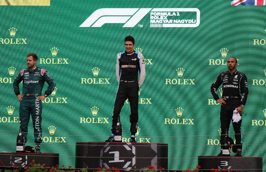 (De izquierda a derecha) El piloto alemán de Aston Martin, Sebastian Vettel, el piloto francés de Alpine Esteban Ocon y el piloto británico de Mercedes Lewis Hamilton celebran en el podio después del Gran Premio de Hungría de Fórmula 1