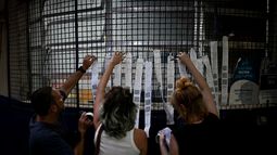 FOTO LEYENDA 1: Trabajadores electorales y representantes de partidos locales fotografían las hojas de resultados impresas en un centro de votación al concluir la jornada electoral en Río de Janeiro, Brasil, el 25 de octubre de 2026. AFP