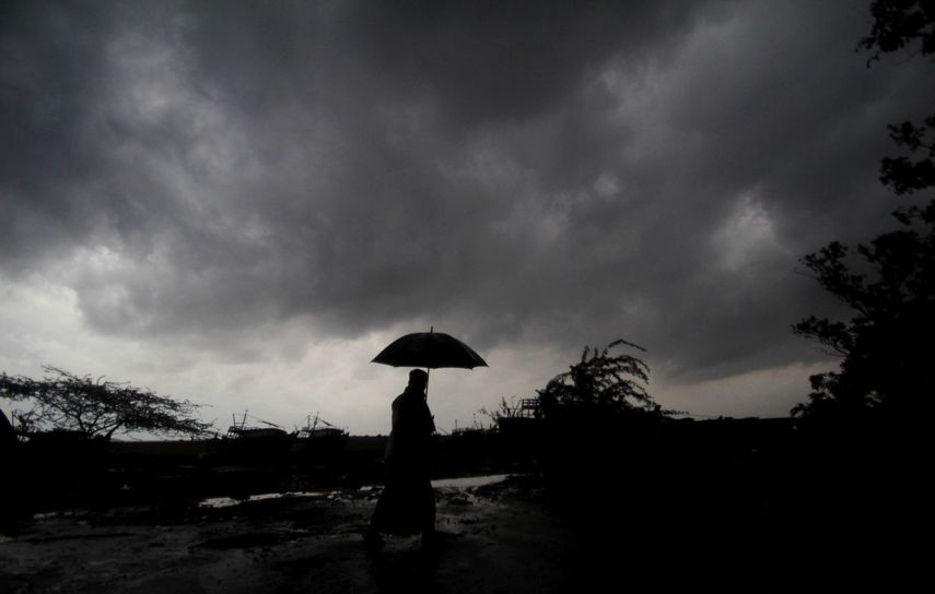 Una persona sostiene un paraguas mientras las nubes oscuras se ciernen sobre el distrito de Balasore en Odisha, India, el martes 25 de mayo de 2021, antes de que una poderosa tormenta se dirija hacia la costa oriental.&nbsp;