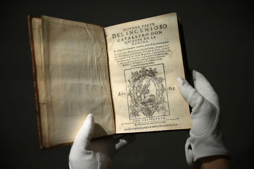 Esta foto de archivo tomada el 25 de noviembre de 2022 muestra a una persona sosteniendo uno de los dos volúmenes de la novela Don Quijote, de Miguel de Cervantes, en la casa de subastas de Sothebys en el centro de Londres, Reino Unido, el 14 de diciembre de 2022.
