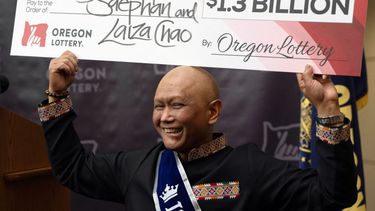 Cheng Saephan levanta un cheque después de hablar en una conferencia de prensa el lunes 29 de abril de 2024 en las oficinas de la Lotería de Oregon, en Salem, Oregon, en la que se reveló que fue uno de los ganadores del premio de 1.300 millones de dólares de la lotería Powerball.&nbsp;