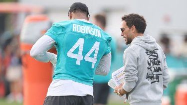 Mike McDaniel y Chop Robinson #44 de los Miami Dolphins hablan durante la práctica en el Baptist Health Training Complex el 28 de julio de 2025 en Miami Gardens, Florida.