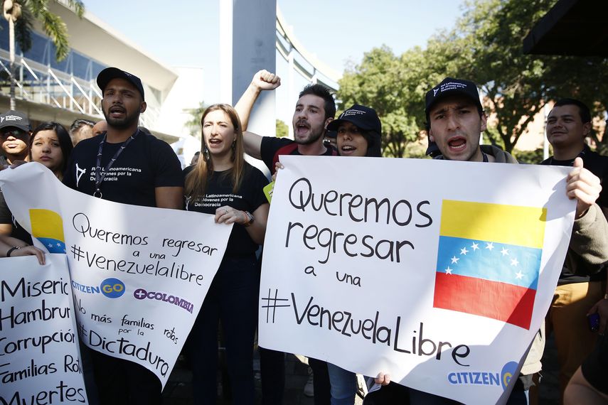 La manifestación, a la cual acudieron cerca de cien personas vestidas con camisetas negras, fue convocada por la Red Latinoamericana de Jóvenes por la Democracia que llegaron a las afueras del centro de convenciones Plaza Mayor llevando banderas venezolanas.&nbsp;