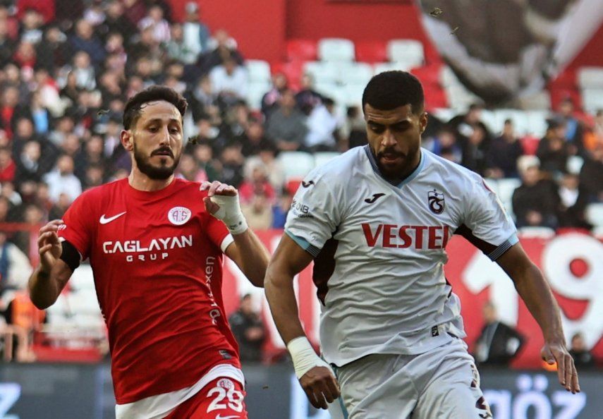 El jugador del Antalyaspor, Sagiv Jehezkel, a la izquierda, lucha por el balón con el jugador del Trabzonspor, Rayyan Baniya, durante un partido de la Superliga turca en Anta Antalyaspor and Trabzonspor en Antalya, en el sur de Turquía, el domingo 14 de enero de 2024.