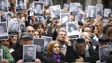 La gente muestra las fotografías de las personas que murieron en el ataque terrorista contra el centro judío AMIA, que mató a 85 personas, en el 25 aniversario del ataque en Buenos Aires, Argentina, el jueves 18 de julio de 2019.&nbsp;