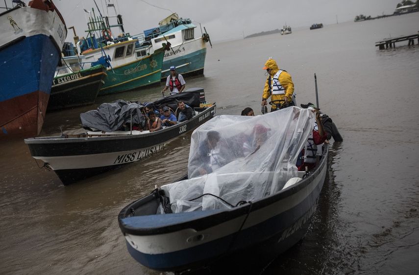 Varias personas salen del puerto en bote para regresar a sus comunidades en medio de la lluvia generada por la tormenta tropical Bonnie, el 1 de julio de 2022, en Bluefields, Nicaragua.&nbsp;