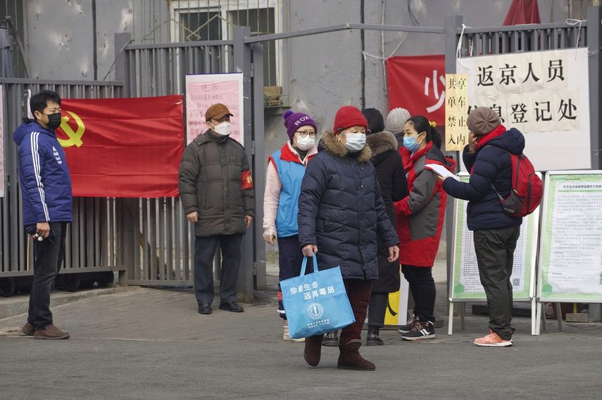 Residentes esperan para entrar a un &aacute;ea que dice punto de registro para personas que regresan a Beijing, en Beijing, China, el jueves 13 de febrero de 2020.