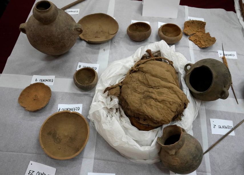 Momias infantiles aparentemente sacrificadas para acompañar a un noble muerto al más allá y vasijas descubiertas recientemente por arqueólogos que trabajan en la segunda ciudad preincaica más grande de Perú se exhiben para una presentación ante los medios en la Universidad de San Marcos, en Lima, el martes 22 de febrero de 2022.