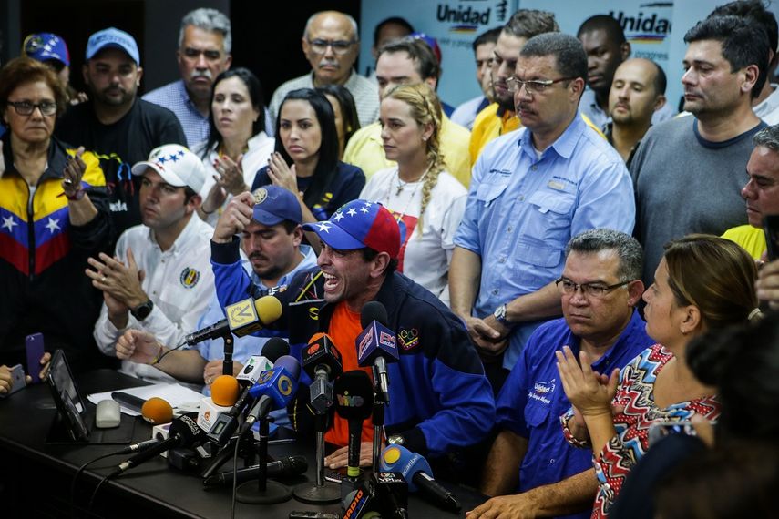El gobernador del estado Miranda, Henrique Capriles (c), habla durante una rueda de prensa, acompañado por la esposa del líder opositor Leopoldo López, Lilian Tintori (c-arriba) y un grupo de diputados opositores de la Asamblea Nacional este miércoles 19 de abril de 2017, en Caracas, Venezuela, y convoca para nueva marcha este jueves.