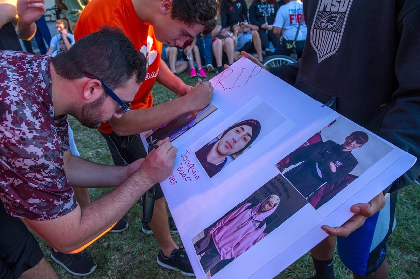 Varios estudiantes firman un poster con fotografías de Joaquín Oliver, una de las 17 víctimas mortales de la masacre de Parkland, Florida.