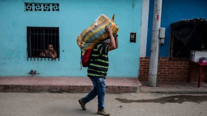Un venezolano porta un paquete que será transportado a Venezuela a través de las llamadas trochas - senderos ilegales- en Cúcuta, Colombia