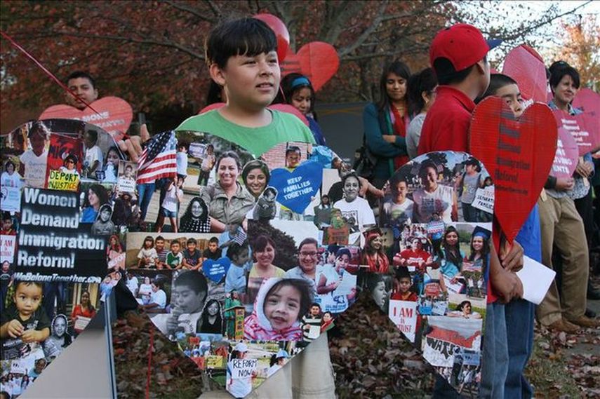 Unos niños sostienen unos carteles con fotos de niños, mujeres y estudiantes dreamers. (EFE ARCHIVO) 