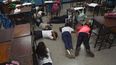 Los alumnos se cubren la cabeza mientras yacen en el suelo durante un simulacro de tiroteo en la escuela Manuel Aguirre en el barrio La Bombilla en Caracas el 23 de febrero de 2023. Simulacros de tiroteos organizados por el Comité Internacional de la Cruz Roja (CICR) se están llevando a cabo en escuelas de algunos de los barrios más violentos de Caracas.