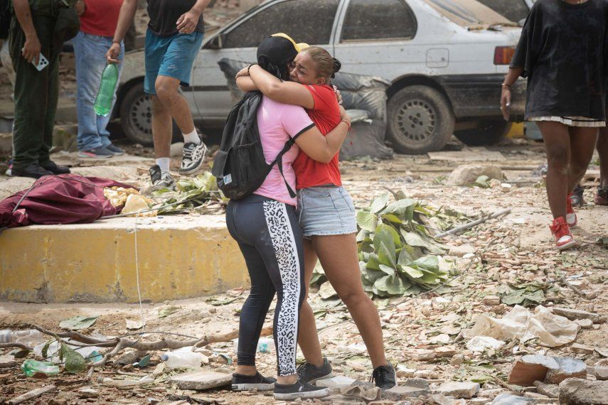 Personas lloran frente a escombros de edificios afectados por terremotos este jueves, en La Guaira (Venezuela).&nbsp; 