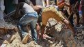 Un grupo de personas trabaja para recuperar un cuerpo enterrado por los escombros de una vivienda luego de un sismo en Los Cayos, Haití, el sábado 14 de agosto de 2021.