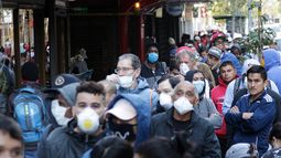 Cientos de personas usando m&aacute;scaras para protegerse del coronavirus COVID-19 hacen fila en Santiago de Chile, mientras esperan un seguro de empleo para los afectados por la pandemia.
