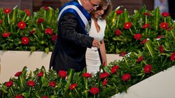 El presidente salvadoreño saliente Mauricio Funes es ayudado por su esposa Vanda Pignato durante la ceremonia de toma de posesión del nuevo presidente salvadoreño Salvador Sánchez Cerén en San Salvador, El Salvador, el 1 de junio de 2014.