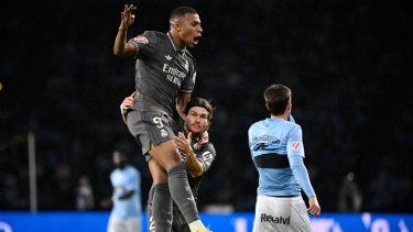 El delantero francés del Real Madrid, Kylian Mbappé, celebra con el defensa español Francisco García tras marcar un gol durante el partido de la liga española ante el Celta de Vigo en el estadio de Balaídos, el 19 de octubre de 2024.&nbsp;