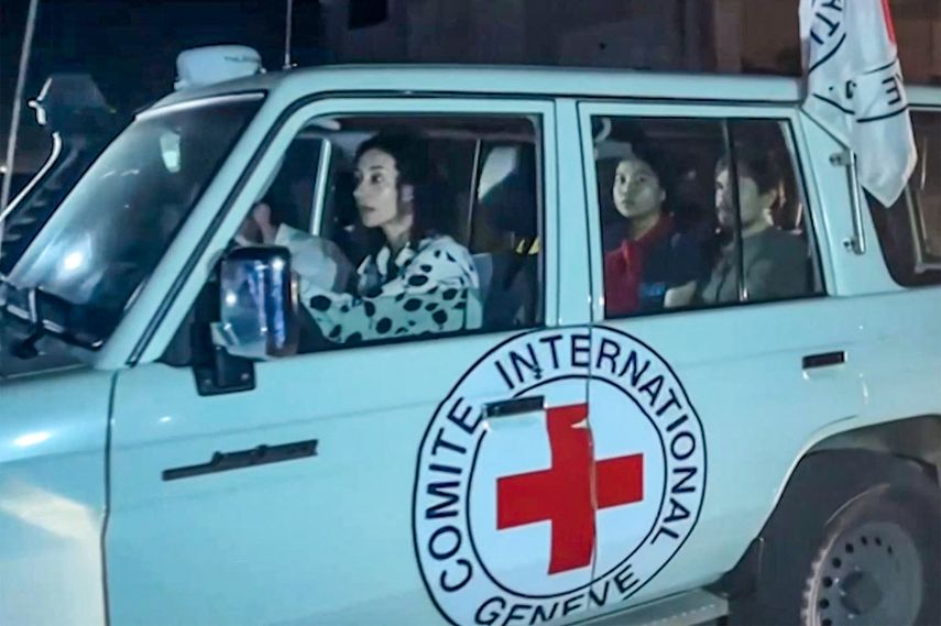 Esta imagen tomada de un video de AFPTV muestra un vehículo de la Cruz Roja Internacional que supuestamente transportaba rehenes liberados por Hamás cruza el punto fronterizo de Rafah en la Franja de Gaza hacia Egipto, desde donde serían trasladados en avión a Israel para reunirse con sus familias, el 24 de noviembre. de 2023.