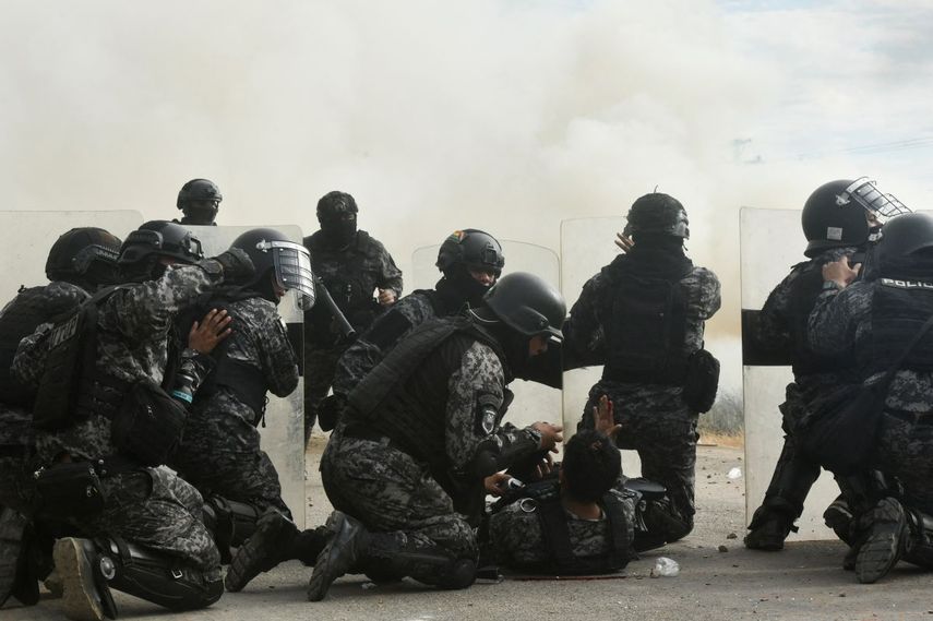 Agentes de policía asisten a un compañero herido durante enfrentamientos con manifestantes antigubernamentales en el marco de una operación para despejar un bloqueo vial en San Julián, departamento de Santa Cruz, Bolivia, el 6 de junio de 2026