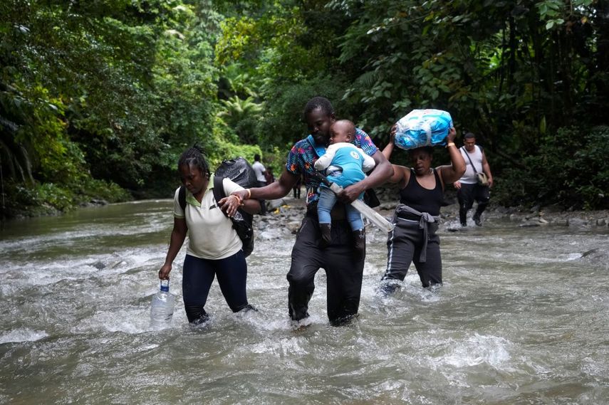 Migrantes haitianos vadean un río en la selva del Darién el 15 de octubre de 2022, en un recorrido de Colombia a Panamá, con la esperanza de seguir luego su viaje hacia Estados Unidos.