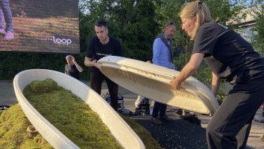 Lonneke Westhoff, directora de la startup holandesa Loop Biotech (derecha) y el fundador de la firma Bob Hendrikx (izquierda) muestran uno de los ataúdes que fabrican, diseñados para disolverse en el medio ambiente en medio de la creciente demanda de prácticas funerarias más sostenibles, el 22 de mayo de 2023 en Delft, Holanda.&nbsp;
