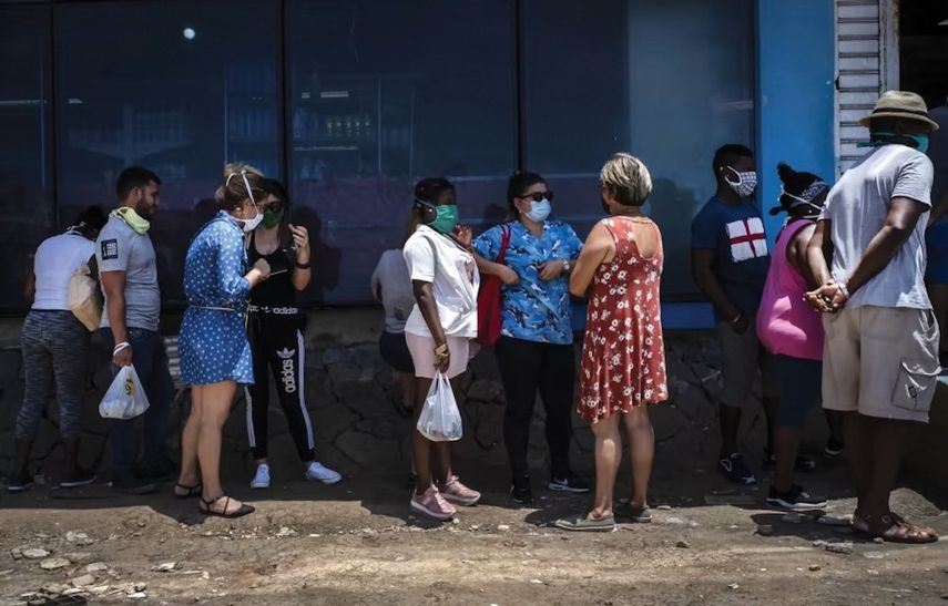 Personas con mascarillas esperan ingresar a una bodega administrada por el régimen de La Habana. Personas con mascarillas esperan ingresar a una bodega administrada por el régimen de La Habana.