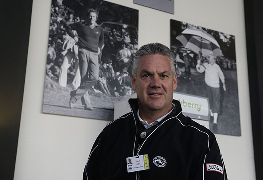 Steve John, director ejecutivo de la Monterey Peninsula Foundation y director del torneo de golf Pro-Am de Pebble Beach, posa frente a fotografías de Clint Eastwood. (AP)