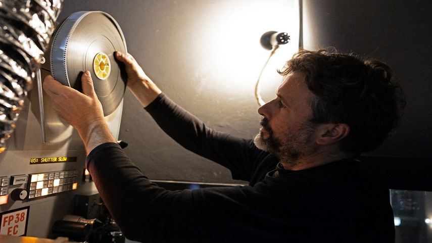 El proyeccionista Martín Ramírez sostiene una lata de película que contiene los carretes 6 y 9 de Oppenheimer, de Christopher Nolan, en la Cinemateca Uruguaya de Montevideo el 3 de agosto de 2023.