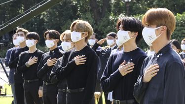 La banda sudcoreana BTS saluda su bandera nacional durante una ceremonia para conmemorar el Día Nacional de la Juventud en la Casa Azul presidencial en Seúl, Corea del Sur, el 19 de septiembre de 2020. La banda ha desatado polémica en China.&nbsp;