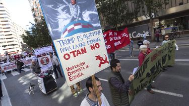 Un manifestante porta una pancarta en contra del presidente Donald Trump, durante la marcha que con motivo del Primero de Mayo, ha recorrido este lunes el centro de Murcia, España.
