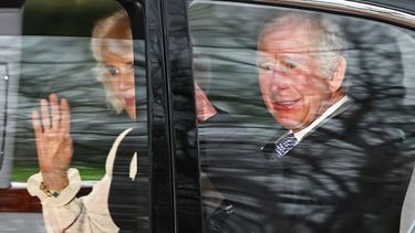 El rey Carlos III de Gran Bretaña y la reina Camilla saludan mientras salen en automóvil desde Clarence House en Londres el 6 de febrero de 2024.