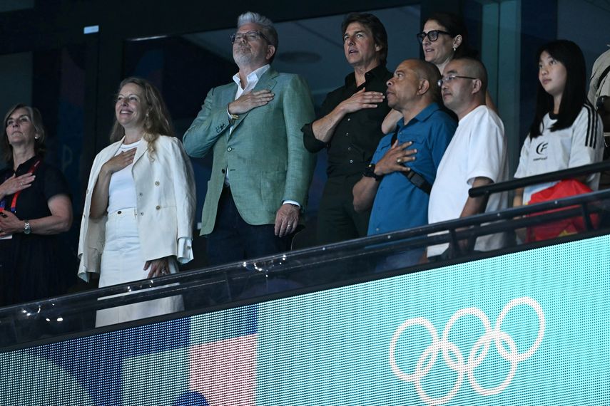 El actor estadounidense Tom Cruise canta el himno nacional de Estados Unidos durante la ceremonia de victoria del evento femenino de natación con relevos estilo libre 4x100 m en los Juegos Olímpicos de París 2024.