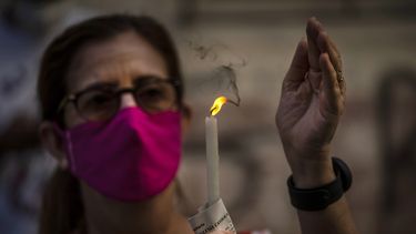 Una mujer con mascarilla sostiene una vela encendida durante una misa cat&oacute;lica transmitida por radio en honor a la Virgen de la Caridad del Cobre, en su fiesta en La Habana, Cuba, el martes 8 de septiembre de 2020.