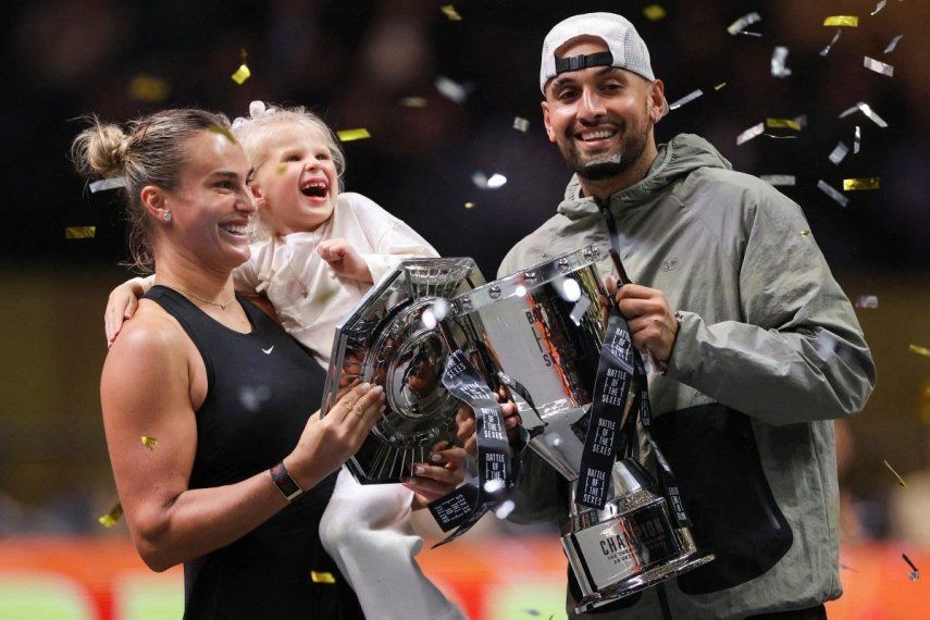Aryna Sabalenka (izquierda), su ahijada Nicole y Nick Kyrgios de Australia celebran con los trofeos al final del partido de tenis de exhibición de la Batalla de los Sexos en Dubai el 28 de diciembre de 2025.