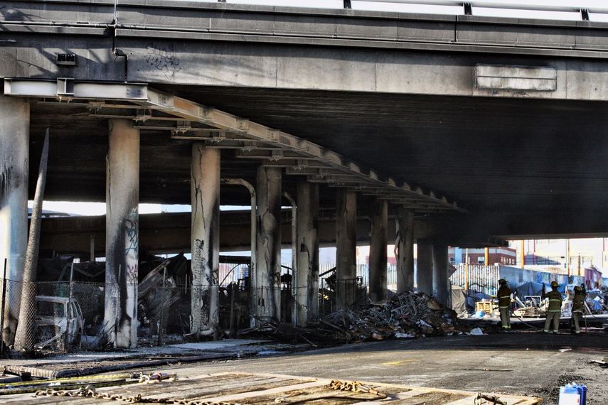 Los bomberos limpian los restos de un incendio bajo la autopista interestatal 10, el cual le causó severos daños a esa vía rápida en una zona industrial, el sábado 11 de noviembre de 2023, cerca del centro de Los Ángeles.&nbsp;