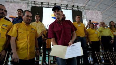 El líder opositor y excandidato presidencial Henrique Capriles muestra el certificado del partido Primero Justicia que lo designa como su candidato presidencial para las primarias de oposición, en Caracas, Venezuela, el viernes 10 de marzo de 2023. 