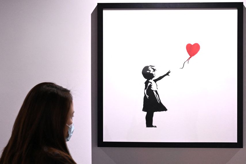 La gente ve el arte de Banksy -un artista callejero, activista político y director de cine radicado en Inglaterra- el día de la inauguración de la exposición El arte de Banksy sin límites, en Melbourne, el 21 de junio de 2024.