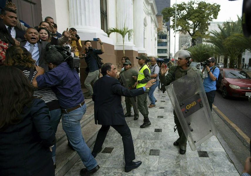 En esta imagen, tomada el 18 de junio de 2019, legisladores de la Asamblea Nacional de Venezuela forcejean con miembros de la Guardia Nacional Bolivariana en el exterior de la sede del organismo, mientras los diputados intentar dar acceso a periodistas, en Caracas, Venezuela.&nbsp;&nbsp;