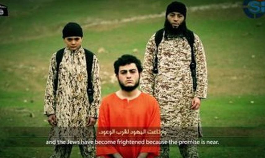 Los terroristas del Ejército Islámico difundieron un nuevo video donde un niño (izquierda) ejecuta a un prisionero. (Internet)