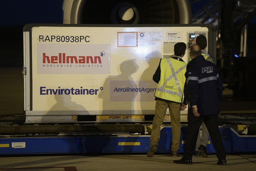 Contenedores con 384.000 dosis de la vacuna desarrollada por Sinopharm de China contra COVID-19, se descargan de un avión de Aerolíneas Argentinas en el Aeropuerto Internacional Ezeiza de Buenos Aires, el 25 de abril de 2021.