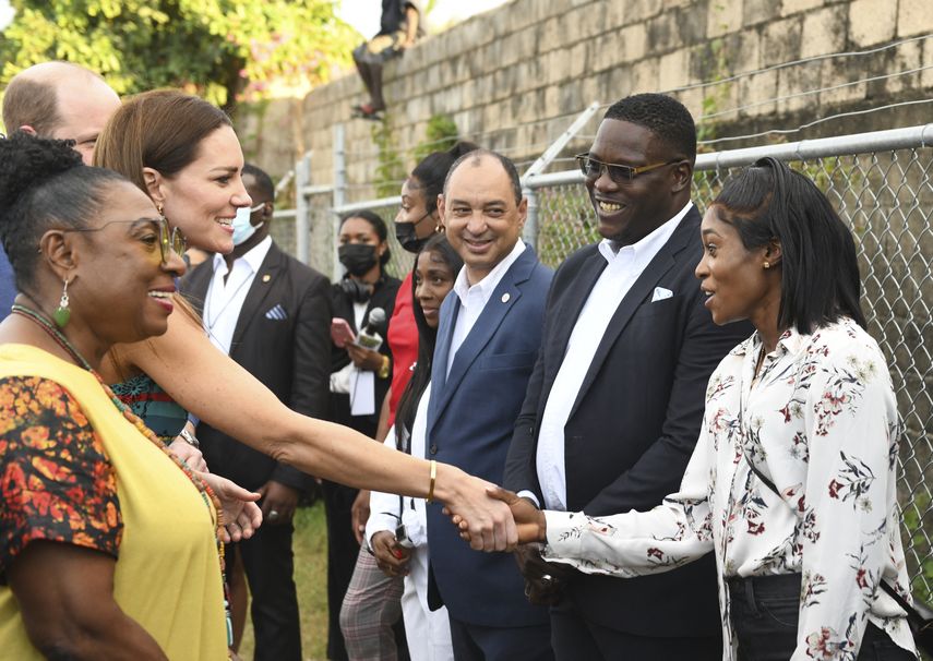 Kate Middleton, duquesa de Cambridge, es recibida por la medallista olímpica jamaicana Elaine Thompson-Herah mientras recorre la comunidad de Trench Town en Kingston, Jamaica, el 22 de marzo de 2022.&nbsp;
