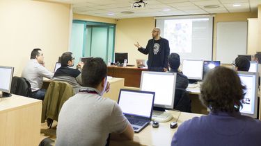 Estudiantes universitarios escuchan una explicación del profesor.