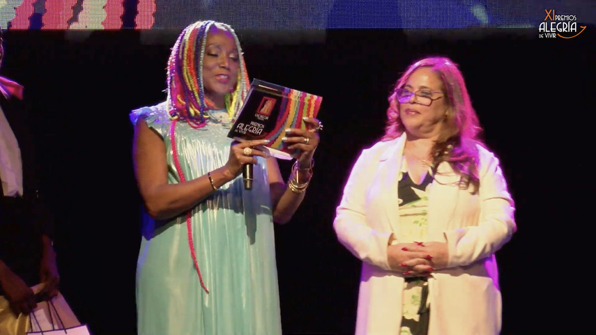 La cantante Lucrecia, creadora de los Premios Alegría de Vivir, entrega un galardón a Diario Las Américas, que recibe Iliana Lavastida en Barcelona, España. &nbsp;