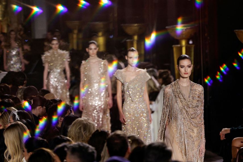 Fotografía tomada a través de un cristal que muestra a modelos presentando creaciones de Elie Saab para el desfile de la colección de alta costura primavera/verano 2026, en el marco de la Semana de la Moda de Alta Costura de París, en París, el 28 de enero de 2026.
