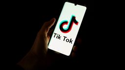 Esta fotografía tomada el 19 de abril de 2024 muestra a un hombre sosteniendo un teléfono inteligente que muestra el logotipo de la plataforma de redes sociales china Tiktok en una oficina en París.