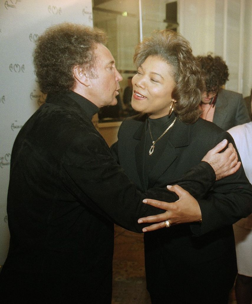 En esta foto de archivo del 13 de diciembre de 1994, Tom Jones besa a Queen Latifah al final de una conferencia de prensa en Beverly Hills, California.