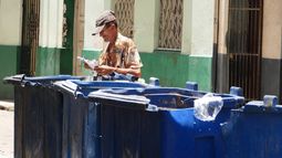 Un hombre busca en la basura en Cuba.